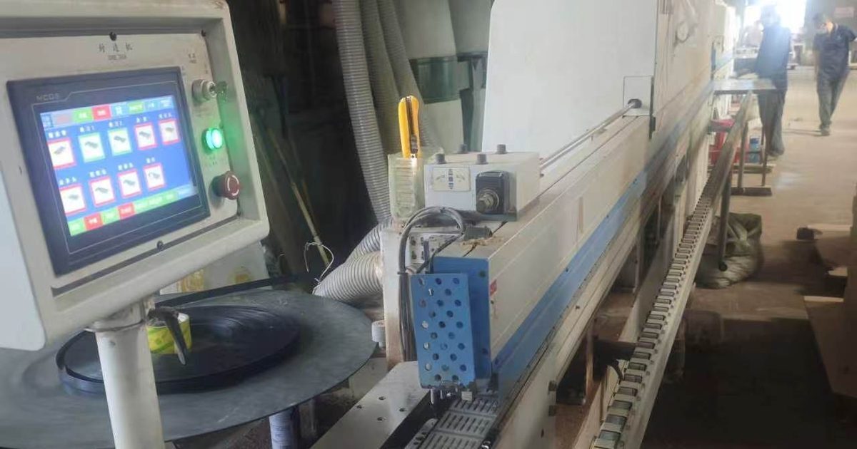 Edge banding machine with touchscreen controls at a furniture factory in China