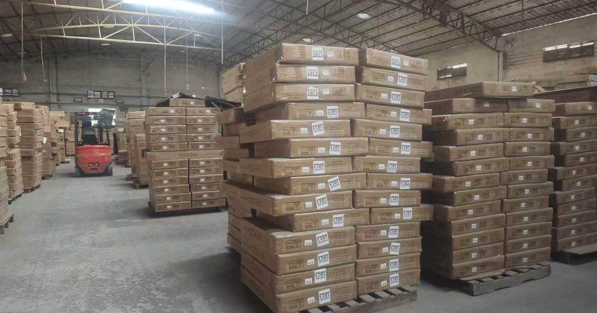 Palletized cartons stacked in a warehouse with a forklift working the aisle in China