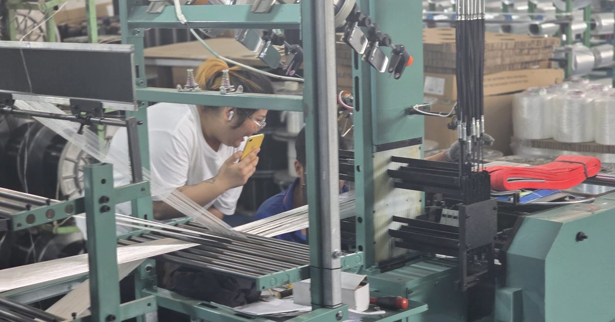 Operator at a narrow-fabric webbing loom on a Chinese production line